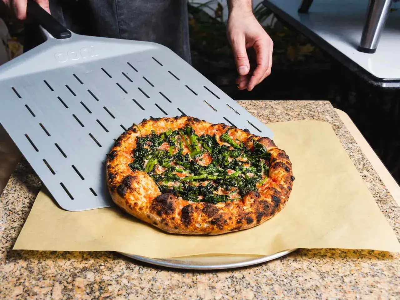 Pyszna pizza z zielonymi warzywami, właśnie wyjęta z pieca. Idealna temperatura pieca pizzy to klucz do chrupiącego ciasta.