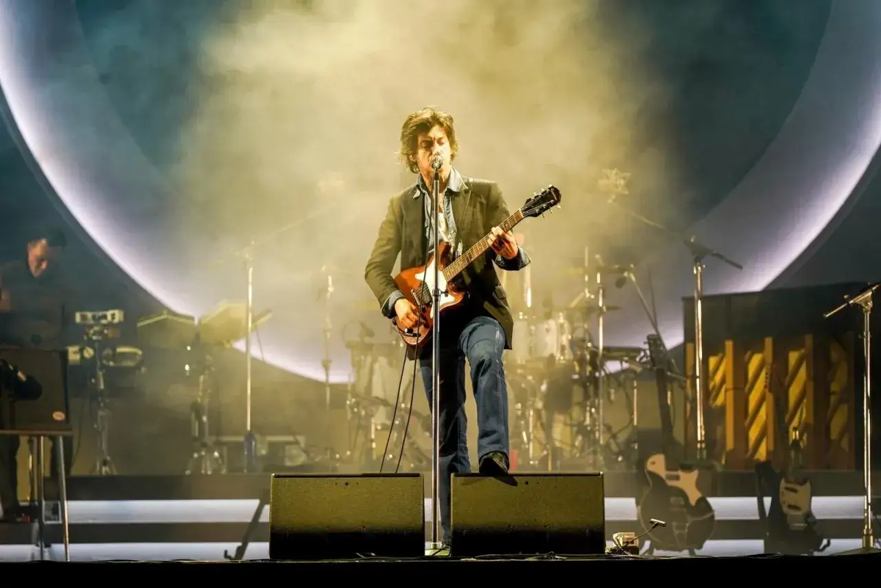 Alex Turner z Arctic Monkeys na scenie, grając na gitarze podczas jednego z niezapomnianych koncertów.