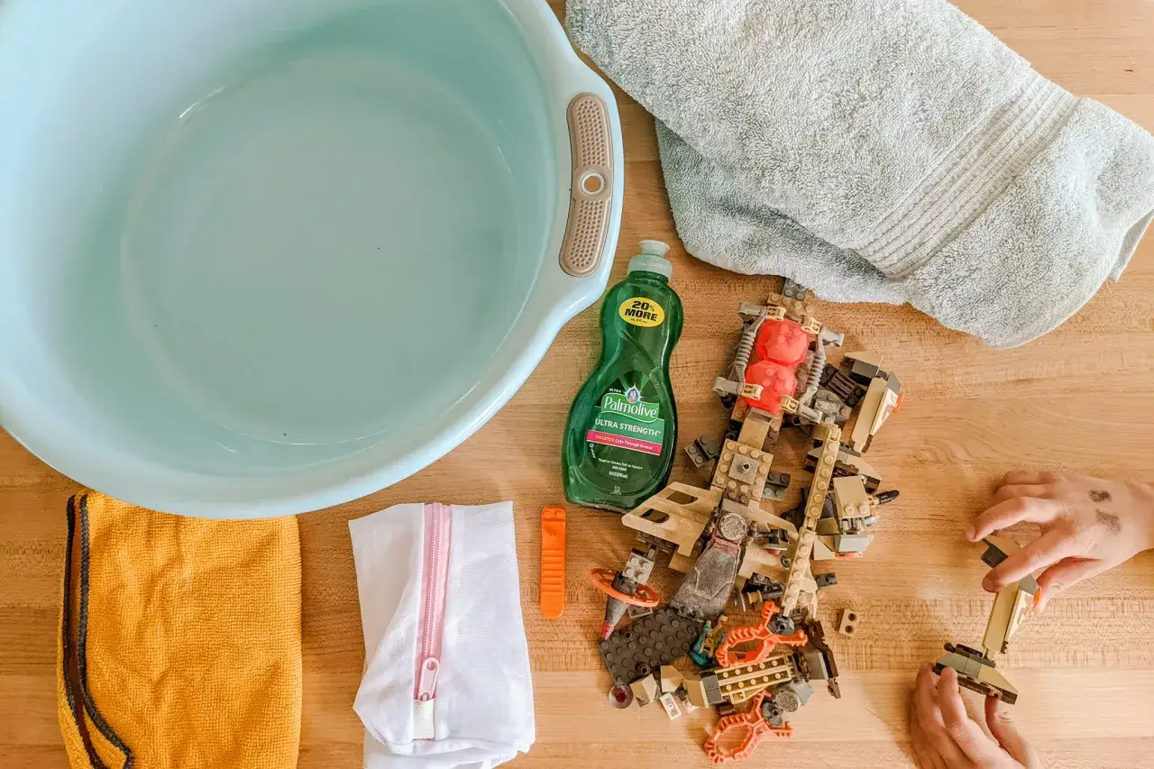 Vorbereitung für das Lego waschen: Schüssel, Spülmittel, Handtücher und ein Lego-Set liegen bereit.