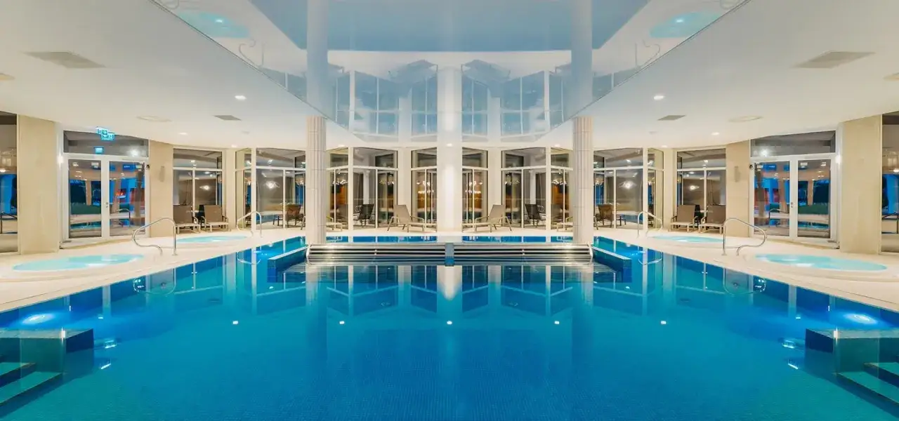 Basen i jacuzzi w Crystal Mountain Resort. Luksusowy basen z błękitną wodą i jacuzzi, otoczony przeszklonymi oknami i wygodnymi leżakami.