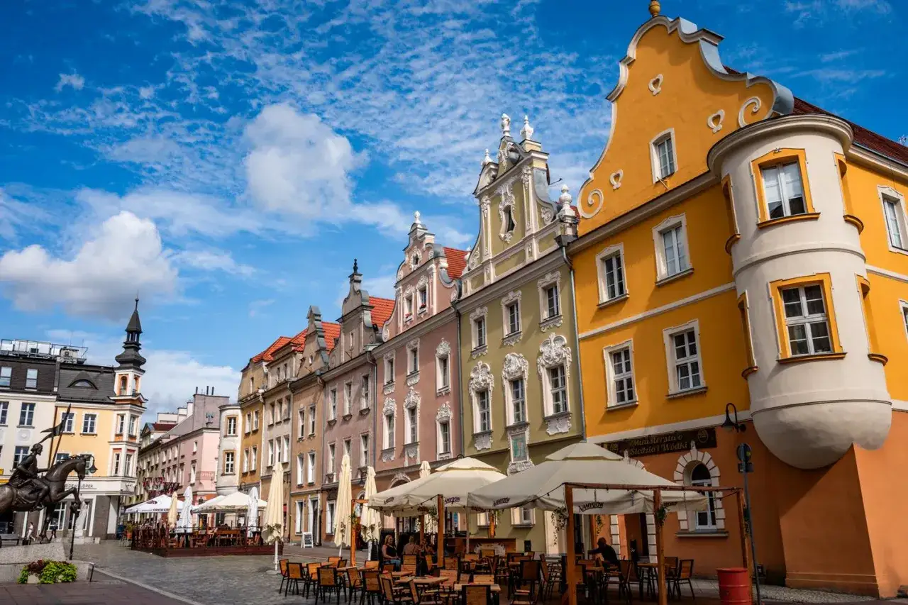 Kolorowe kamienice na Rynku w Opolu, z kawiarnianymi ogródkami i pomnikiem rycerza. Odkryj opolskie atrakcje!