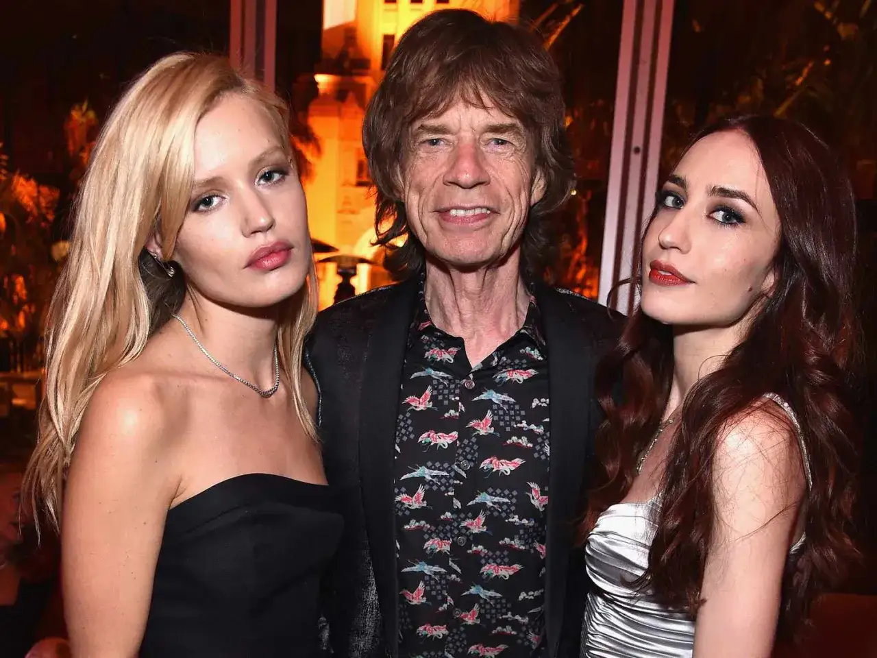 Mick Jagger z dwiema młodymi kobietami, być może jego dziećmi, pozuje do zdjęcia.