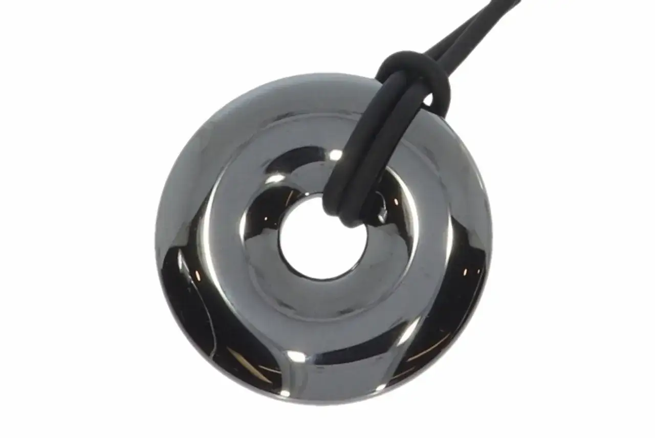 Glänzender Hämatit-Anhänger in Ringform, der an einem schwarzen Band befestigt ist. Trotz seiner Schönheit ist Hämatit nicht giftig.