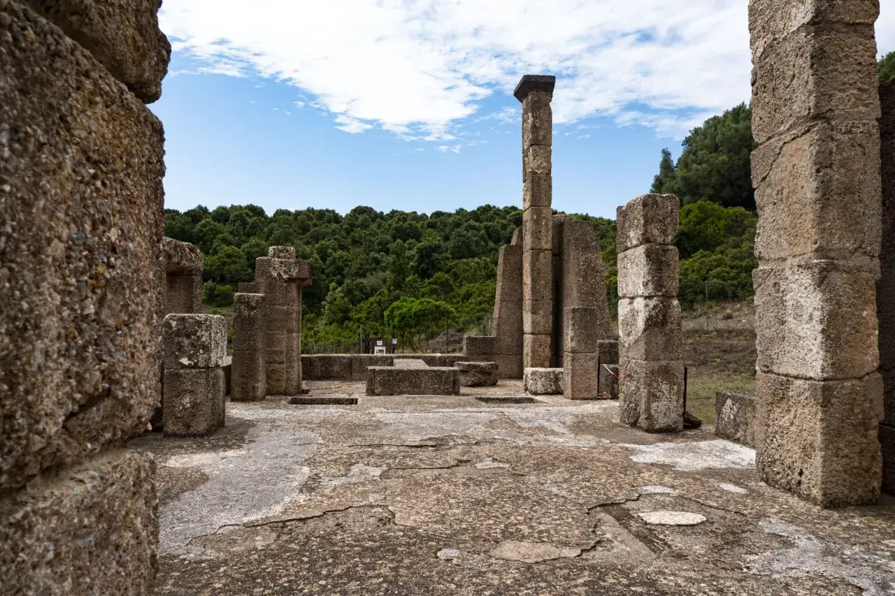 Rovine antiche con colonne di pietra e un cielo azzurro. Un luogo che evoca il **Sardus Pater**, un'antica divinit&agrave; sarda.