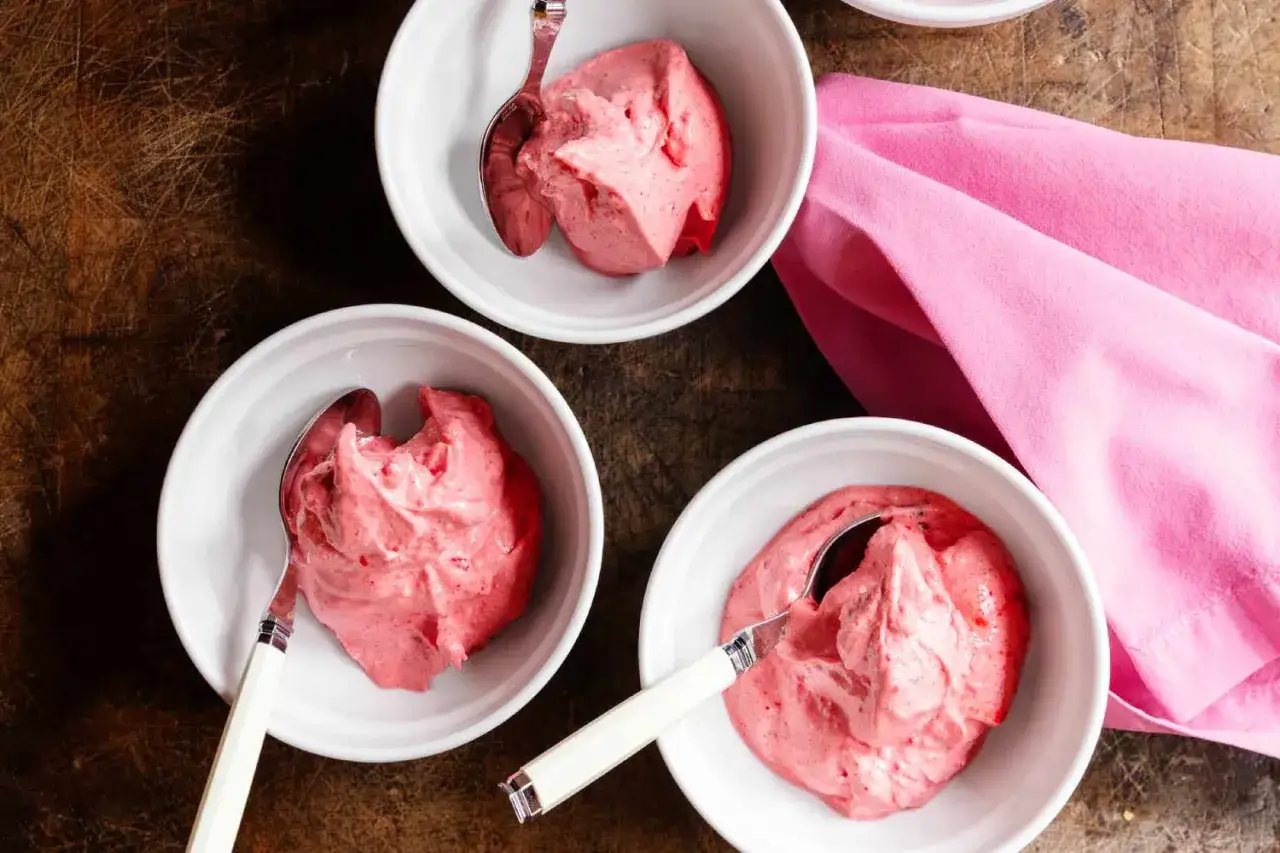 Drei Schalen mit cremigem Erdbeer Sorbet, bereit zum Genießen. Ein Löffel steckt in jeder Schale.