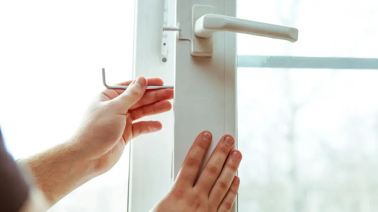 Dłoń z kluczem imbusowym reguluje okno, przygotowując je do trybu zimowego.