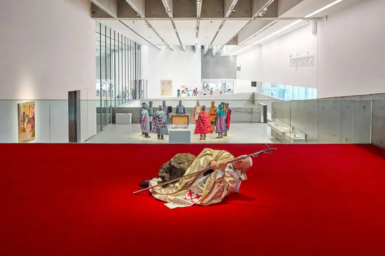 A papal figure lies on a red carpet, a stark contrast to the figures in colorful robes and the