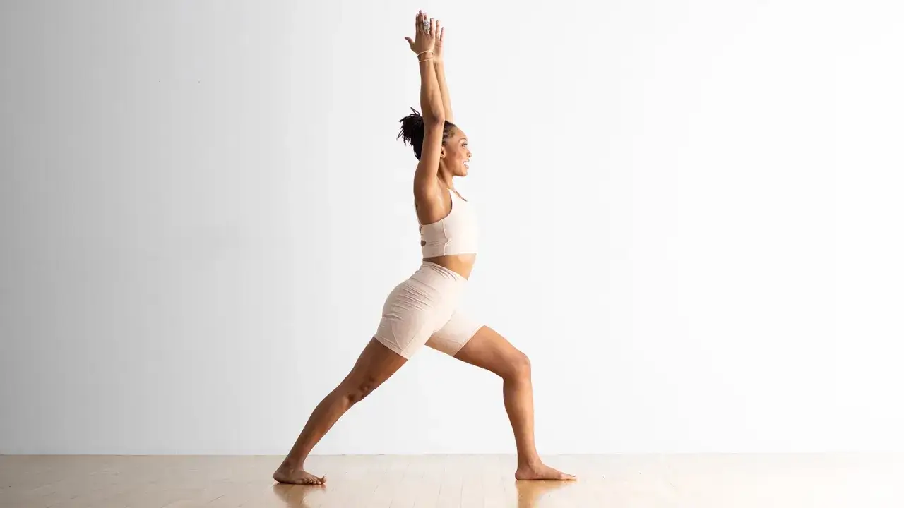 Kvinna i krigarens position, en utmanande yoga-st&auml;llning.
