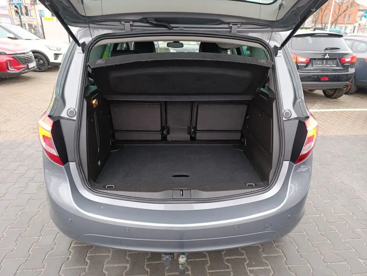 Szary Opel Meriva z otwartym bagażnikiem. Sprawdź, jak duży jest opel meriva pojemność bagażnika, idealny na wakacyjne wyjazdy.