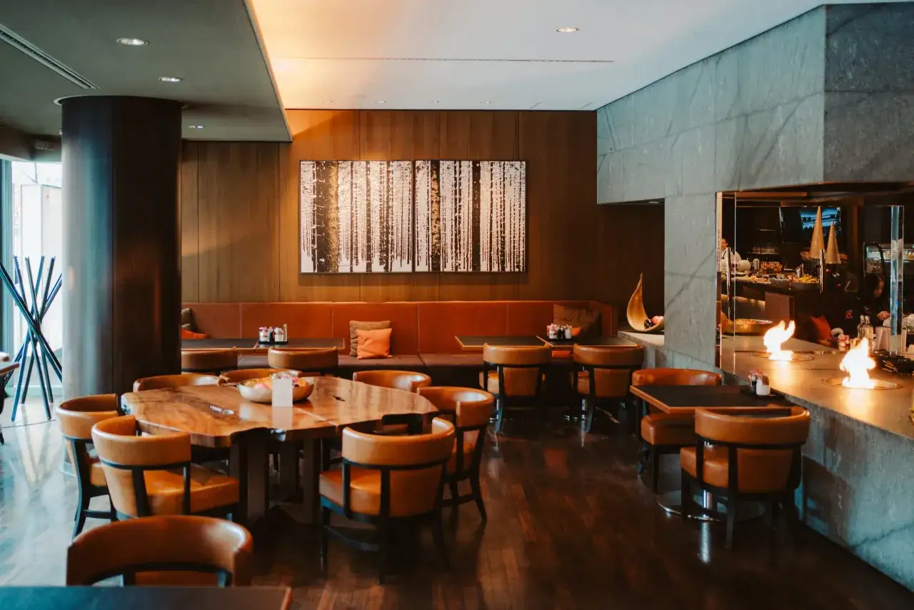 Elegantes Restaurant in Berlin Mitte mit Holztischen, Ledersesseln und einem Kaminfeuer.