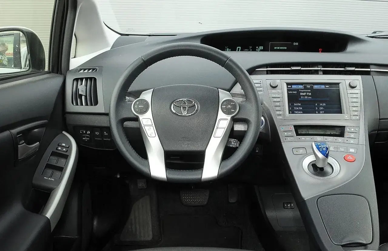 Wnętrze toyoty prius 3: kierownica, panel radia i dźwignia zmiany biegów.