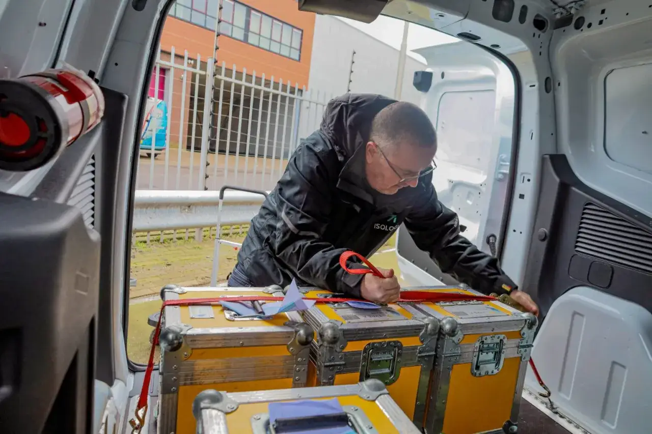 Mann sichert Kisten im Transporter. Die Kisten sind f&uuml;r den Versand vorbereitet, ein wichtiger Schritt f&uuml;r jeden Incoterm.