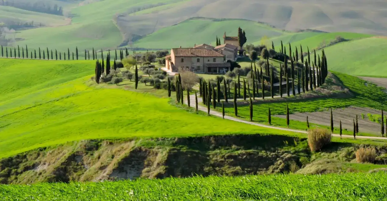 Colline toscane con cipressi e casale, un'immagine iconica di Monteroni d'Arbia cosa vedere.