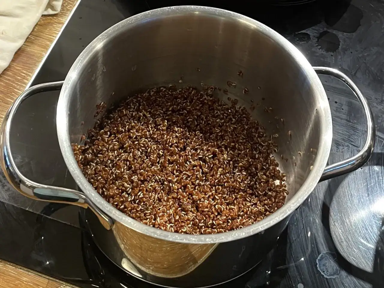 En kastrull med färdigkokt quinoa på en spishäll. Perfekt för att koka quinoa till en hälsosam måltid.