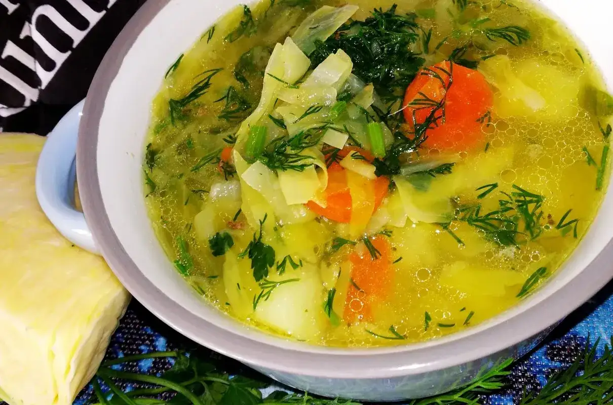 Aromaticzna zupa kapuśniak z młodej kapusty, z kawałkami marchewki i ziemniaków, posypana świeżym koperkiem.