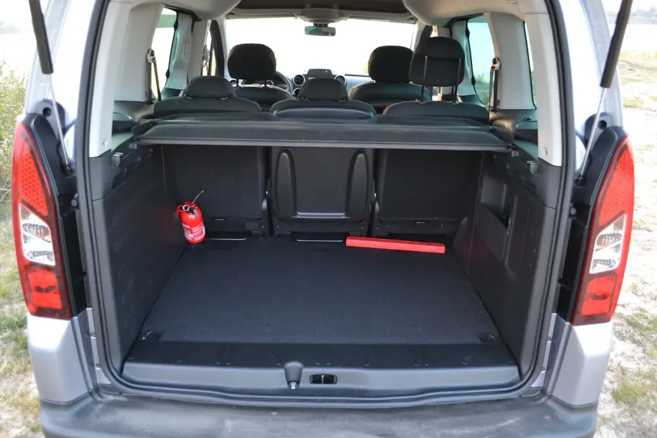 Pusta przestrzeń bagażowa w Berlingo 1.6 HDI. Widoczny gaśnica i trójkąt ostrzegawczy.
