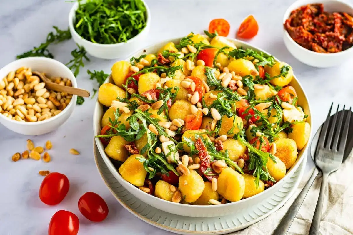 Ein köstlicher Gnocchi-Salat mit Kirschtomaten, Rucola und Pinienkernen. Perfekt für einen leichten Genuss.