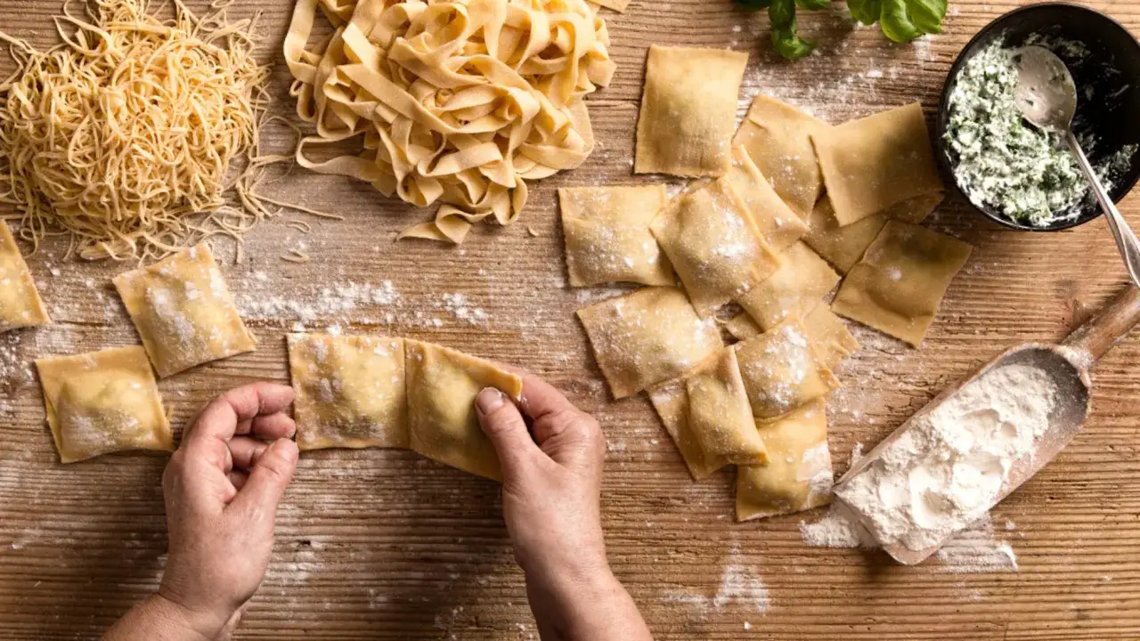 Masa de pasta fresca en forma de volcán con huevos en el centro sobre una superficie de madera