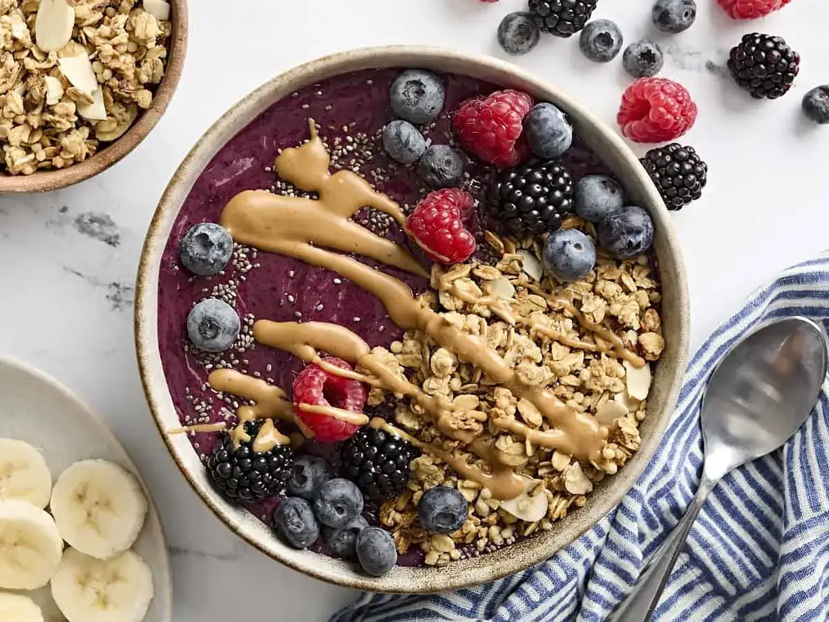 En näringsrik smoothie bowl med bär, granola och jordnötssmör. Perfekt för en hälsosam frukost eller mellanmål.
