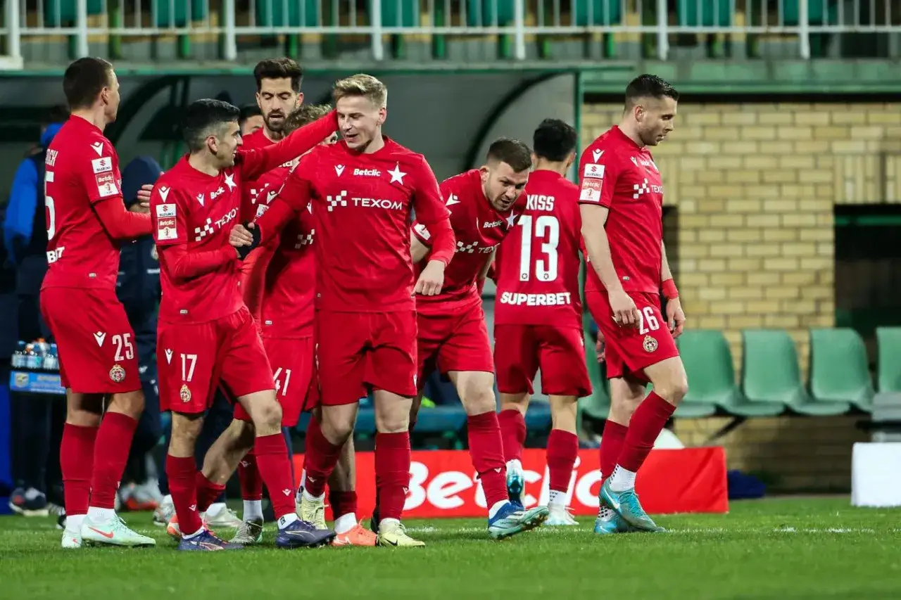 Piłkarze w czerwonych strojach świętują awans do ekstraklasy.