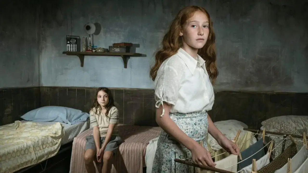 Due bambine in una stanza spartana, una stende il bucato. Ricorda l'arminuta storia vera.