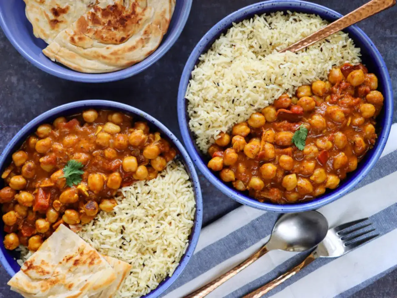 Dos tazones de garbanzos con arroz y pan plano. Un plato reconfortante y sabroso.