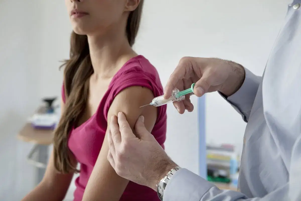 M&eacute;dico administra inyecci&oacute;n anticonceptiva a una mujer en el brazo.