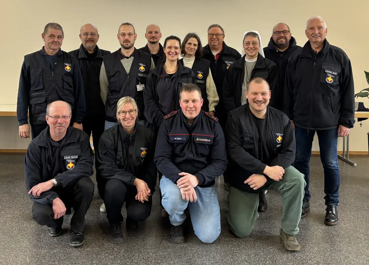 Gruppe von Einsatzkräften der PSNV Feuerwehr posiert für ein Gruppenfoto.