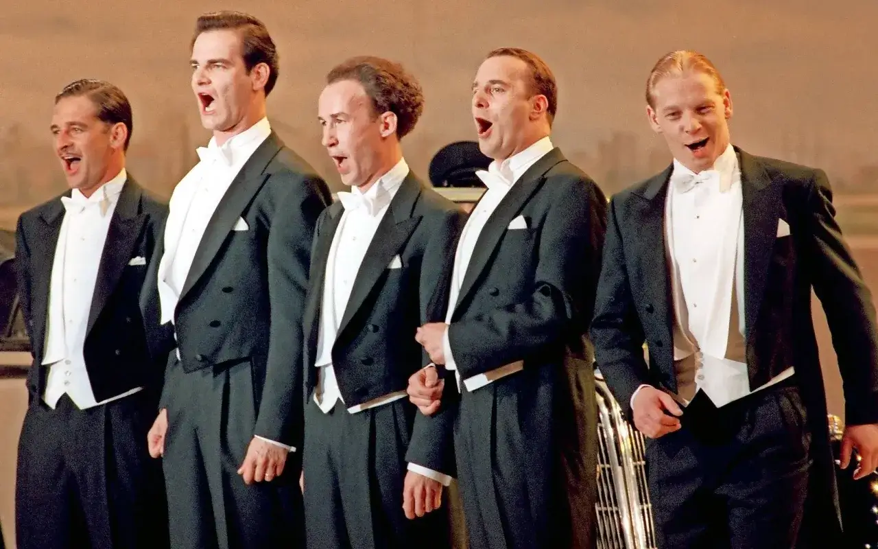 Fünf Männer in Frack und Fliege singen lautstark alte Lieder zum Mitsingen.