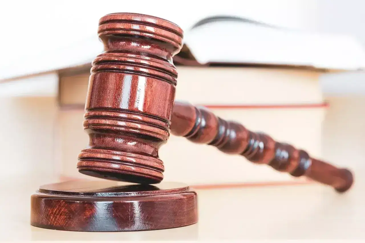 Marteau de juge en bois sur des livres, symbole de justice. Le verdict est tombé, il est condamné aux dépens.