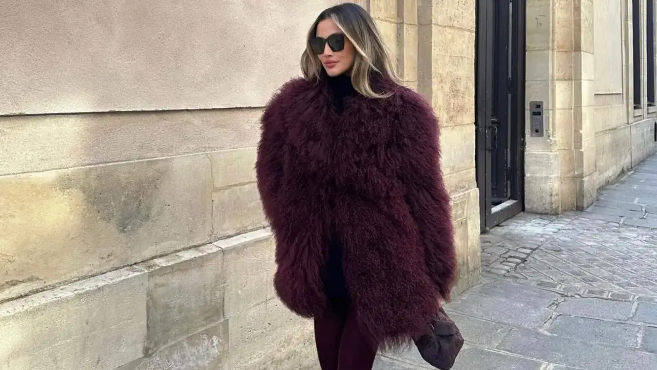 Eleganckie futro w bordowym kolorze, idealne do zimowych stylizacji. Kobieta w okularach przeciwsłonecznych i czarnym golfie prezentuje modny look.