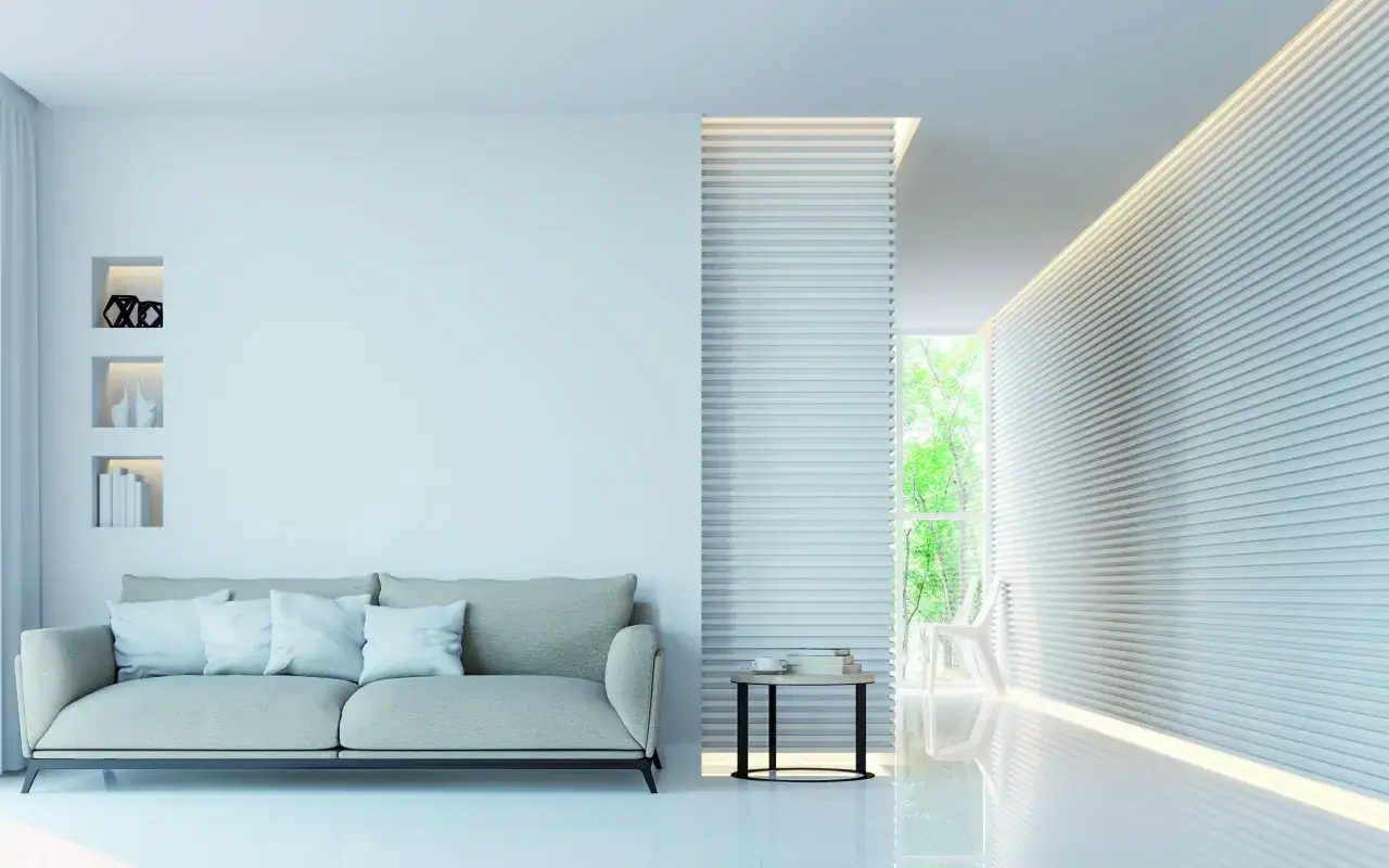 Soggiorno moderno con divano beige, tavolino e libreria a muro. Illuminazione a LED crea un effetto scenografico, con un netto stacco tra parete e soffitto.