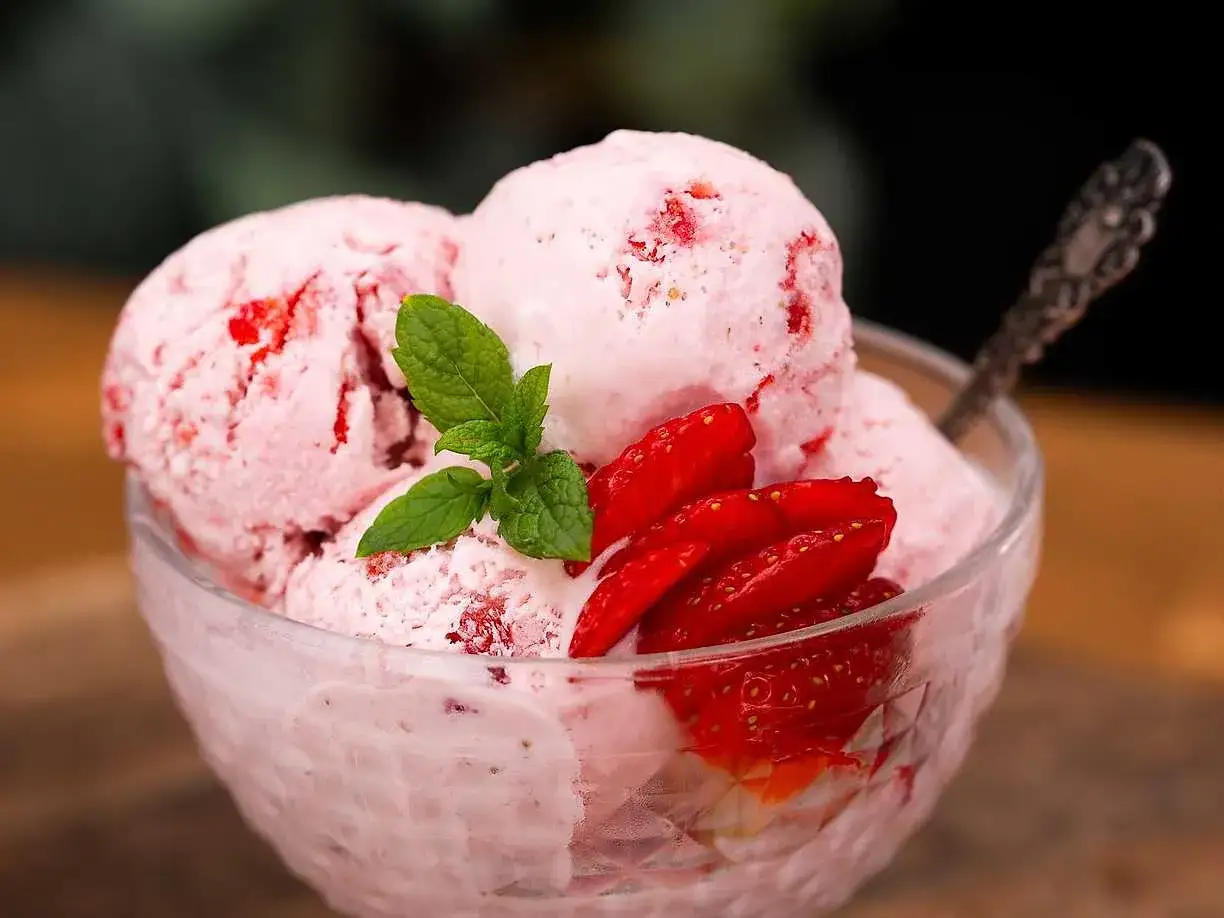 Ljuvlig jordgubbsglass utan glassmaskin, serverad i skål med färska jordgubbar och mynta. En perfekt sommardessert!