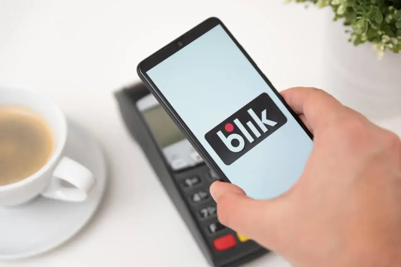 Zbliżeniowa płatność telefonem z logo Blik. Kawa czeka, a transakcja przebiega błyskawicznie.