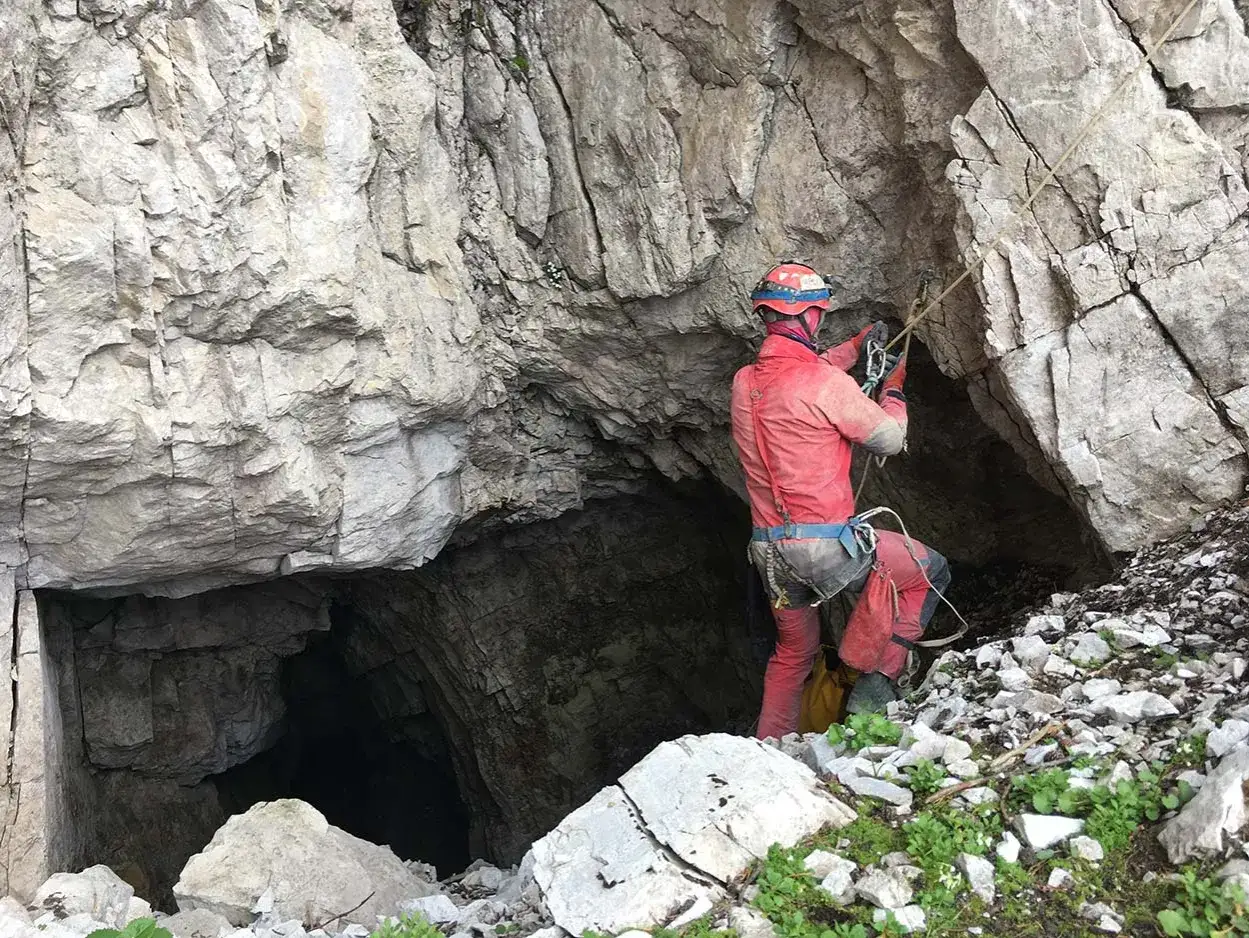 Eksploracja jaskini to prawdziwa przygoda. Speleologia co to? To nauka o jaskiniach, a ten grotołaz przygotowuje się do zejścia.