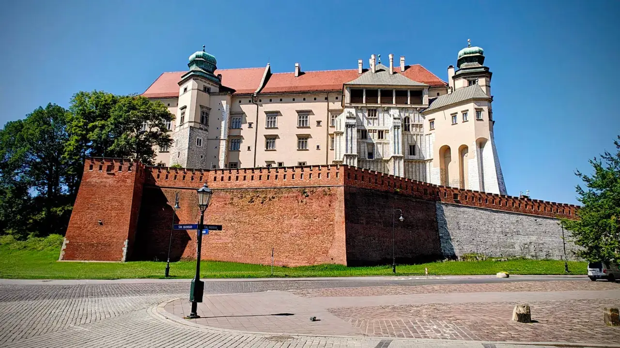 Zamek Królewski na Wawelu, z ceglanymi murami i wieżami, w słoneczny dzień. Sprawdź wawel cennik przed wizytą.