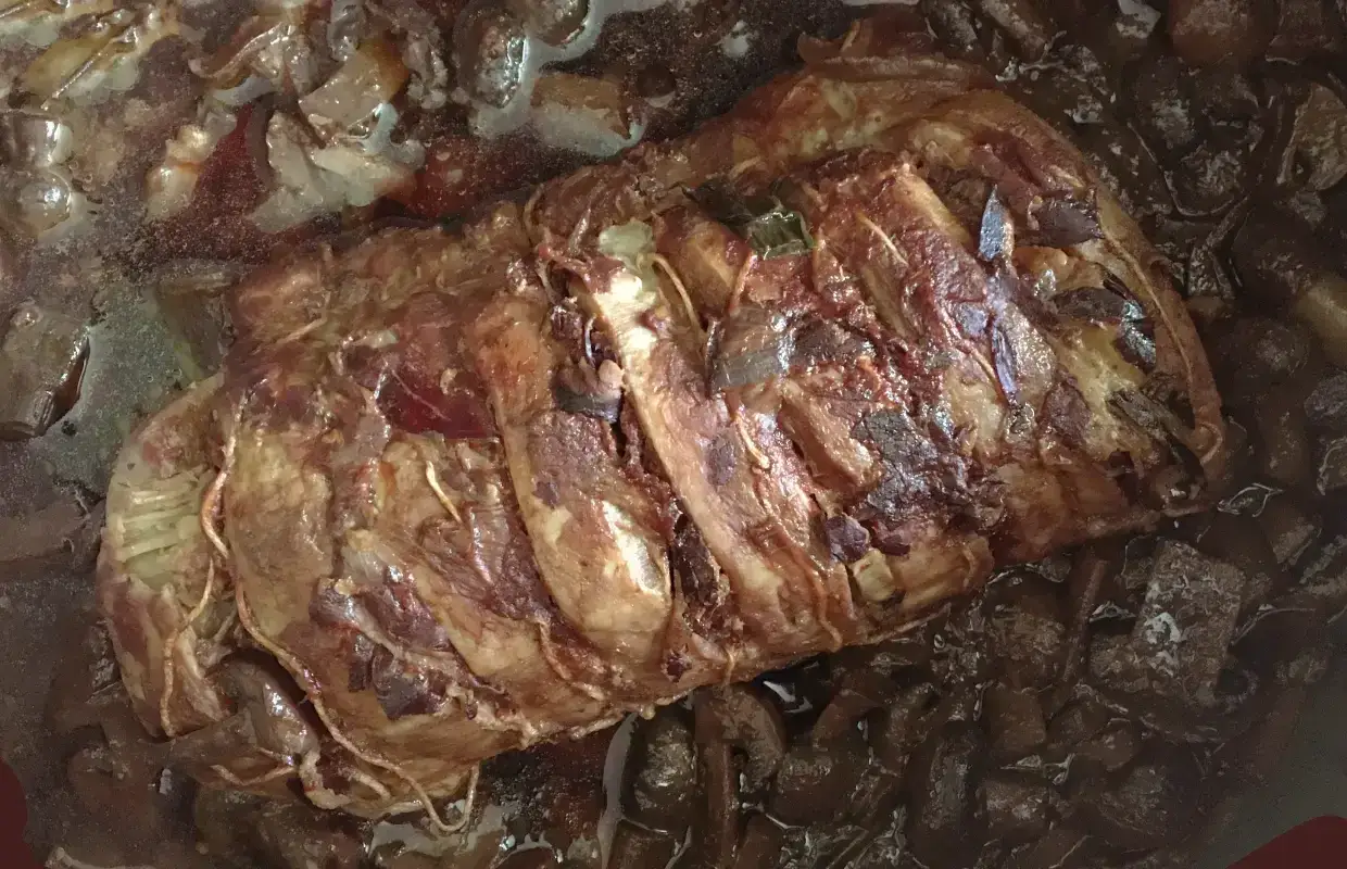 Un r&ocirc;ti de porc mijote dans une sauce brune, pr&ecirc;t &agrave; &ecirc;tre effiloch&eacute;. Les fibres tendres promettent un d&eacute;lice.