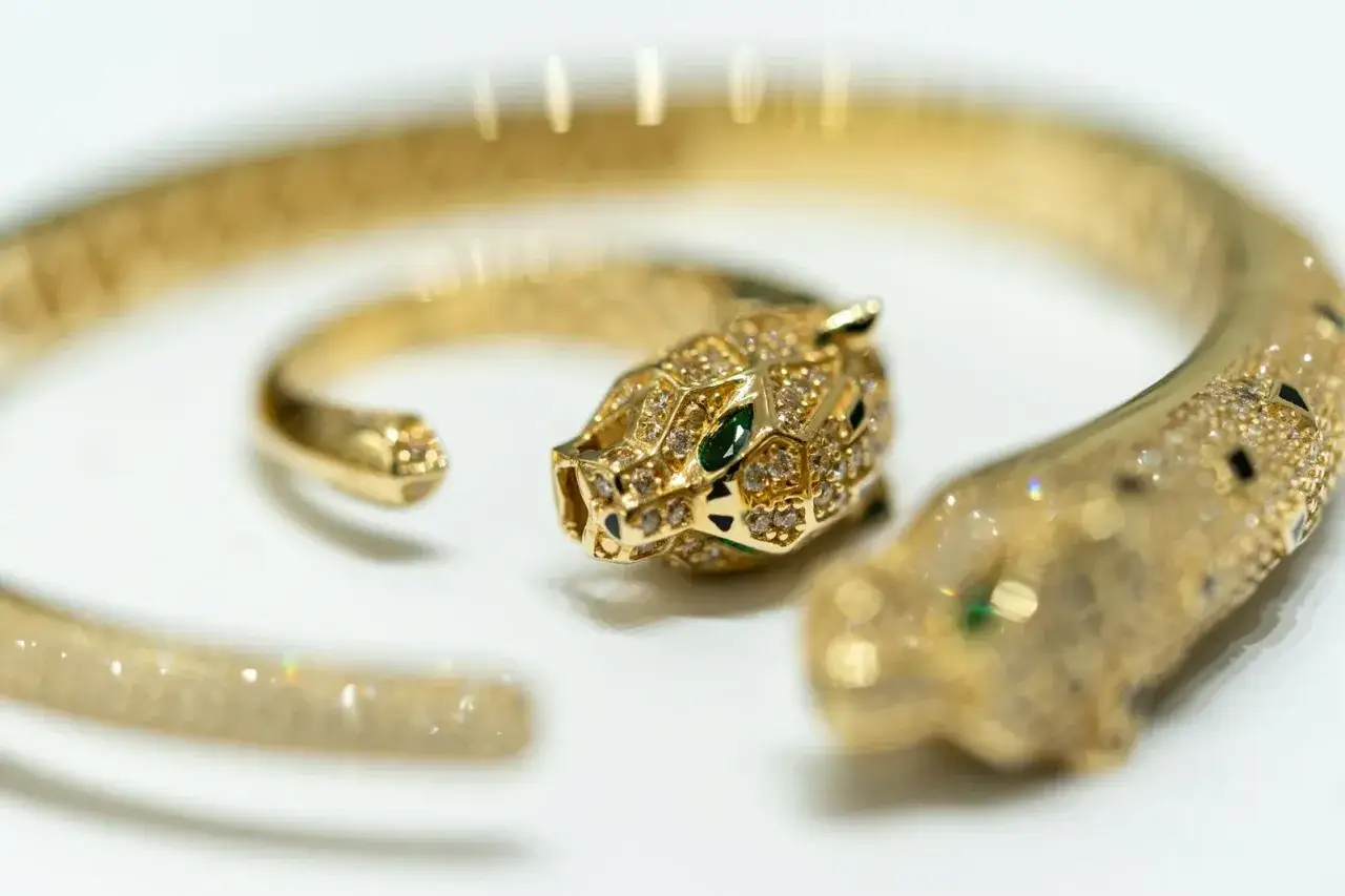 Pulsera de oro con cabeza de pantera, diamantes y esmeraldas. Consulta el precio del oro usado hoy para valorar esta joya.