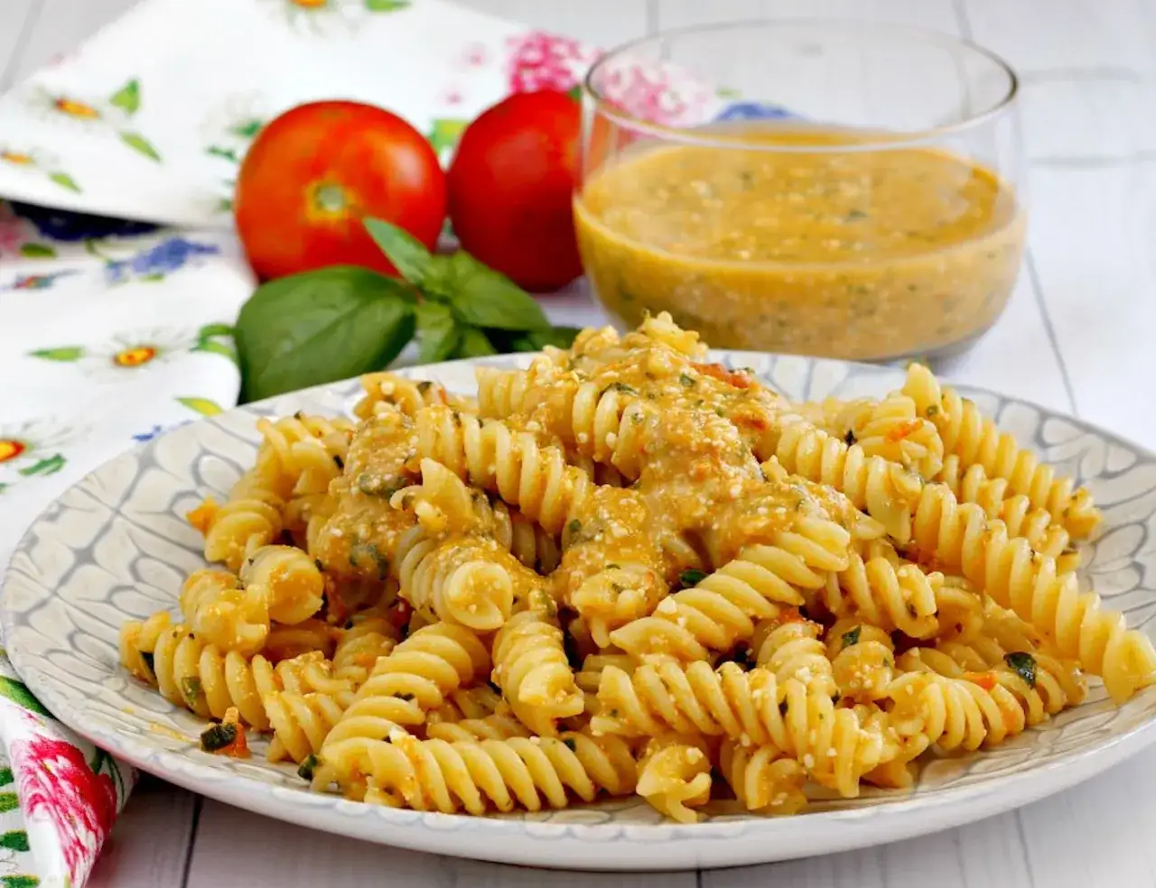 Fusilli conditi con una cremosa salsa di pomodoro e ricotta, guarniti con basilico fresco. Un piatto estivo perfetto.