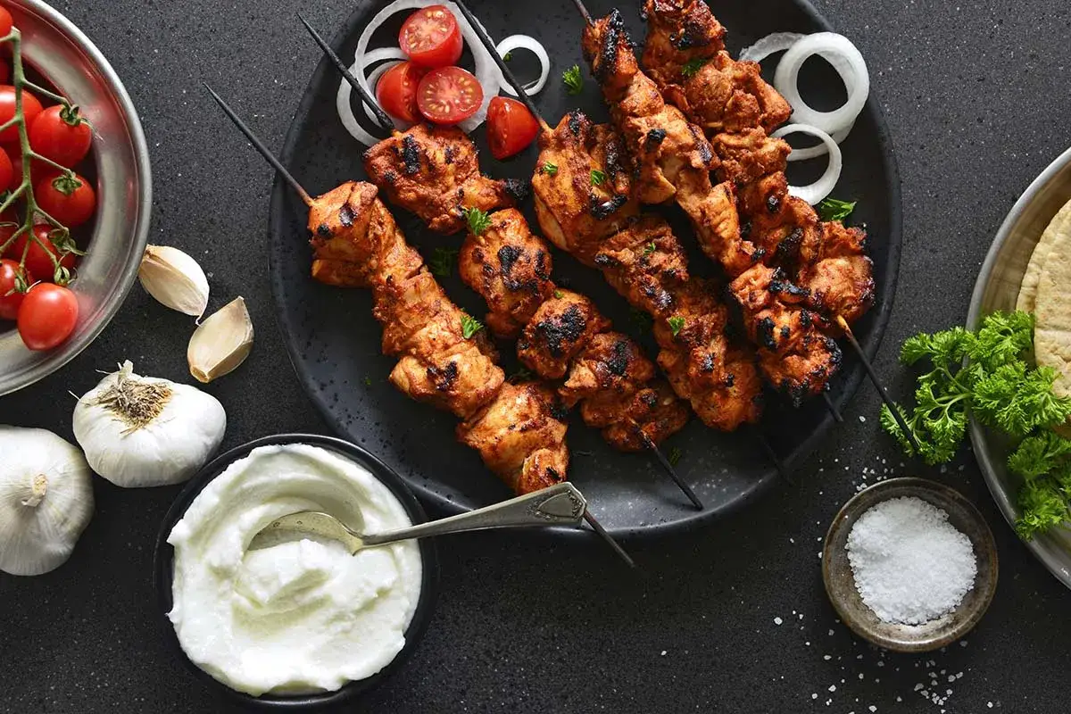 Grillade shish tawook-spett med tomater, lök och vitlöksyoghurt.