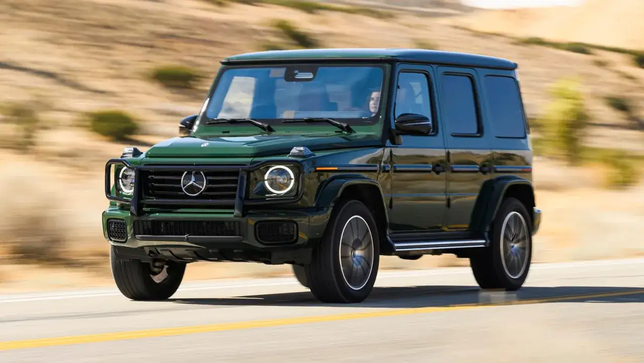 Zielony G-wagon pędzi po pustynnej drodze, budząc podziw swoim kultowym wyglądem.