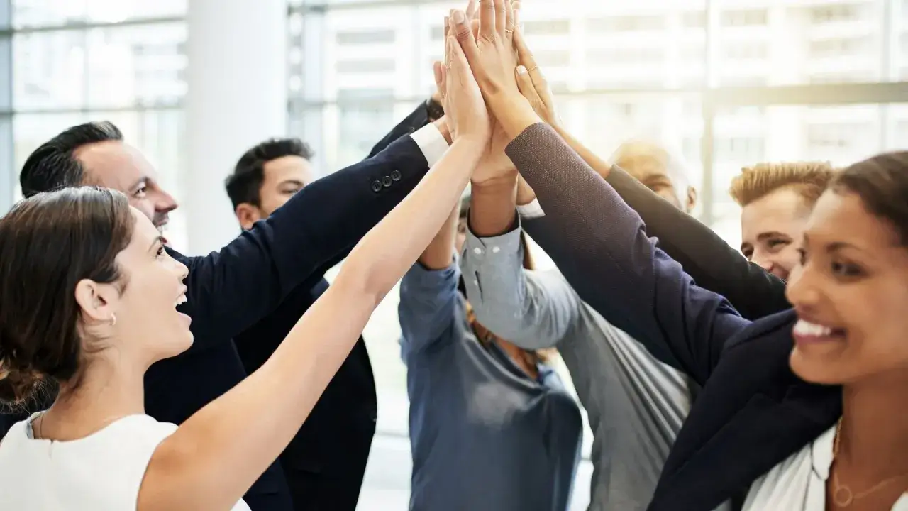 Un team affiatato celebra un successo, un esempio di come motivare i dipendenti con spirito di squadra e gioia condivisa.