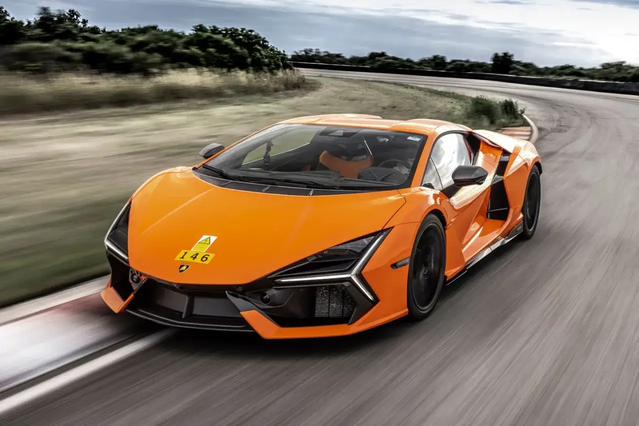 Pomarańczowy Lamborghini Revuelto pędzi po torze wyścigowym, zostawiając za sobą smugę prędkości.