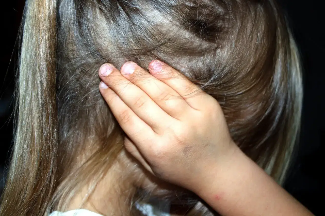 Mano di bambino copre l'orecchio, un gesto che evoca l'angoscia, il suo significato psicologico profondo.