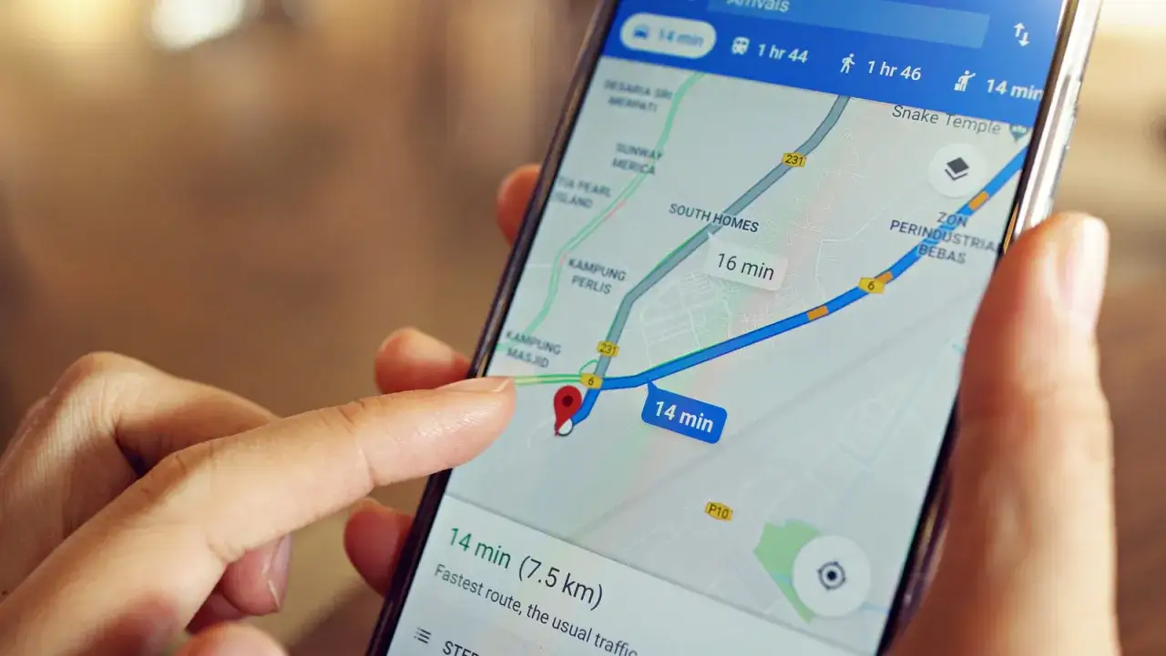 Palec dotyka ekranu smartfona z mapą Google, pokazując trasę. Dowiedz się, jak zlokalizować telefon przez Google.