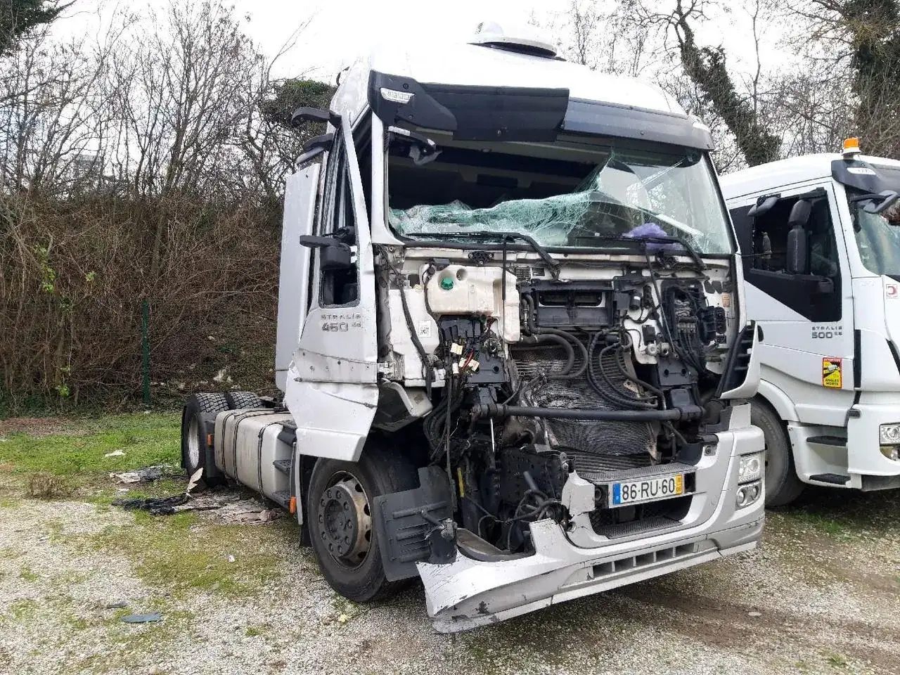 Uszkodzona kabina Iveco Stralis 450, z widocznym silnikiem i pękniętą szybą. Obok stoi inny, nienaruszony Iveco Stralis.