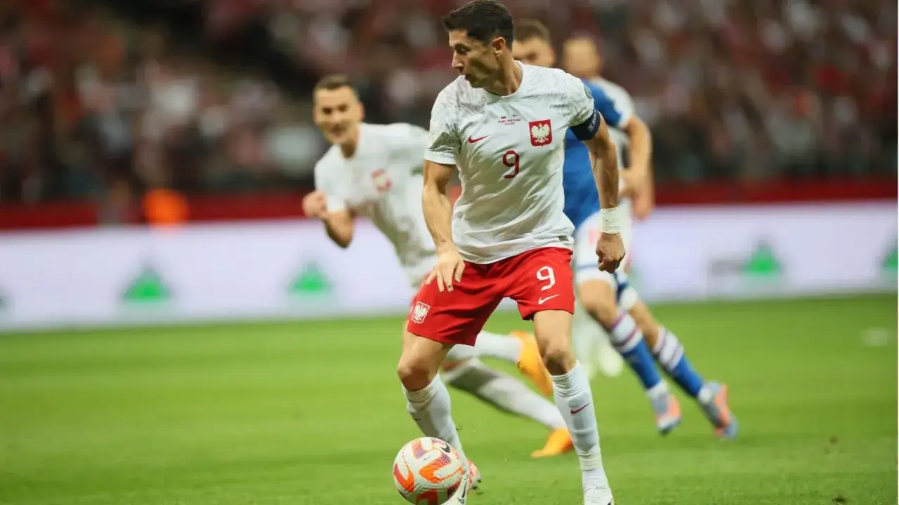 Robert Lewandowski prowadzi piłkę, jakby to była polska wyspy owcze, w meczu reprezentacji Polski.