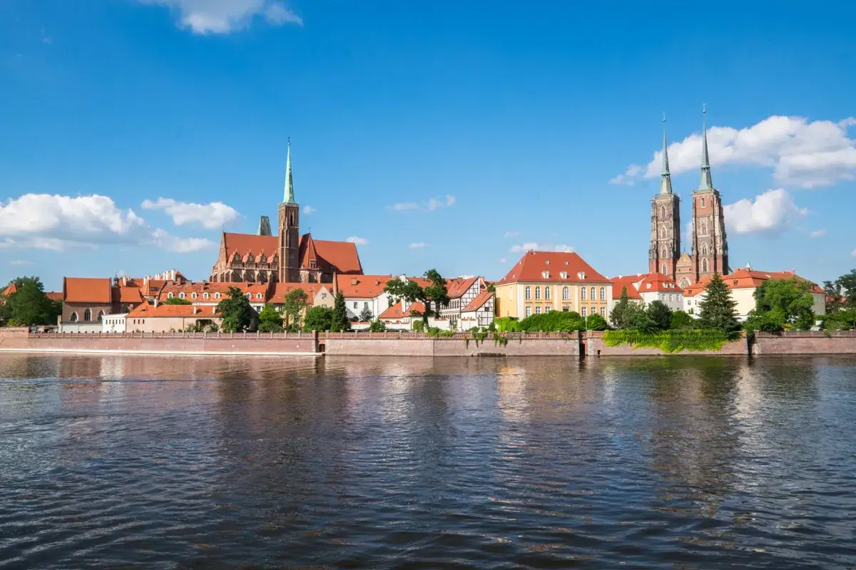 Wrocław, stolica województwa dolnośląskiego, z katedrą i wieżami na tle błękitnego nieba.