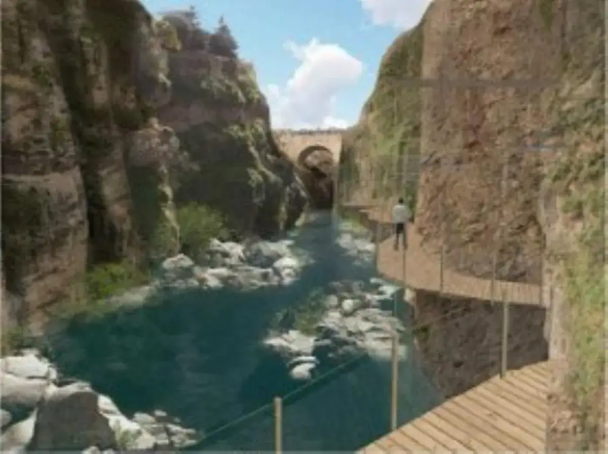 Pasarela de madera recorre los impresionantes gorges de la Fou, con un río turquesa y un puente antiguo al fondo.