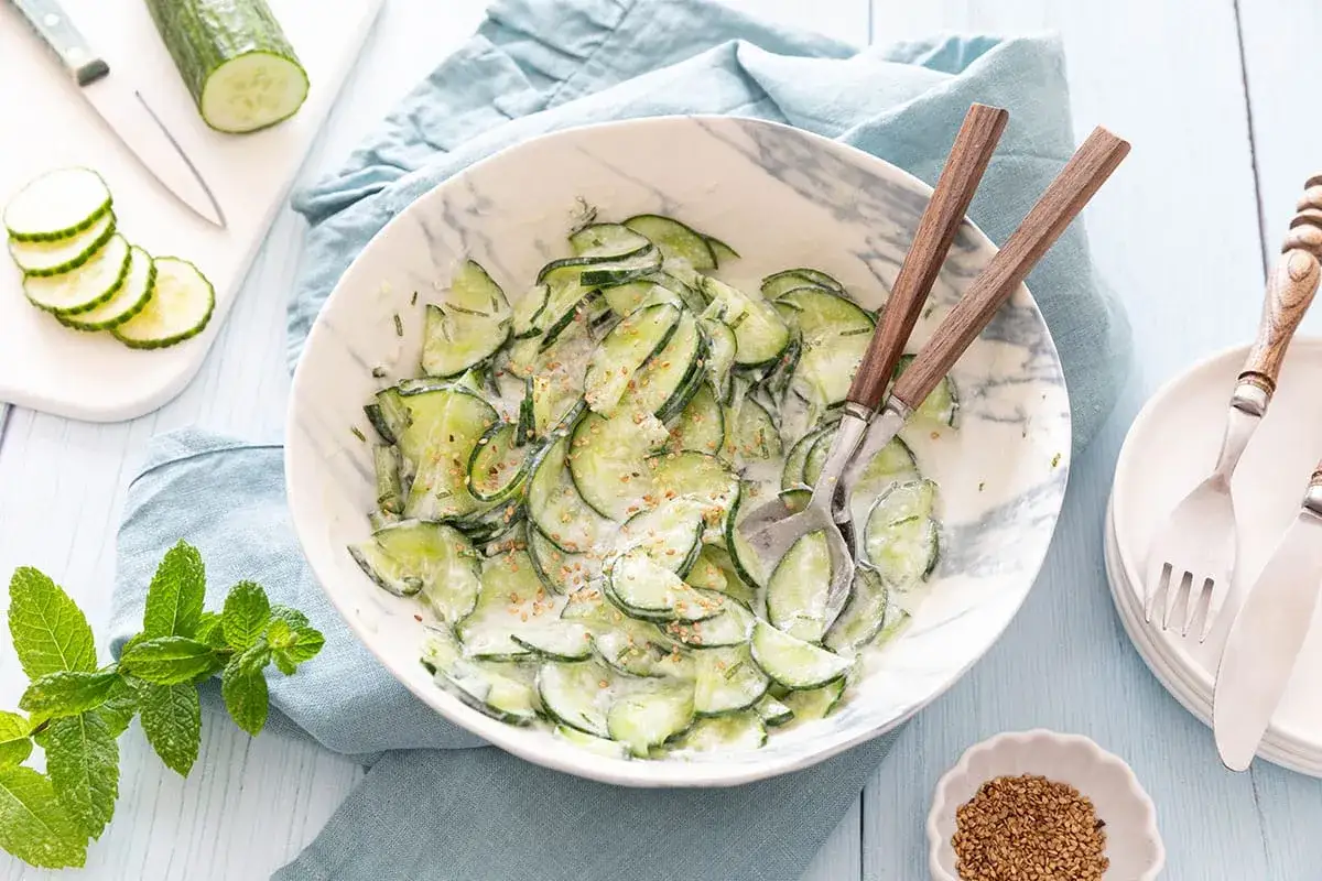 Une d&eacute;licieuse recette salade concombre cr&eacute;meuse, garnie de graines de s&eacute;same. Parfait pour un repas l&eacute;ger et rafra&icirc;chissant.